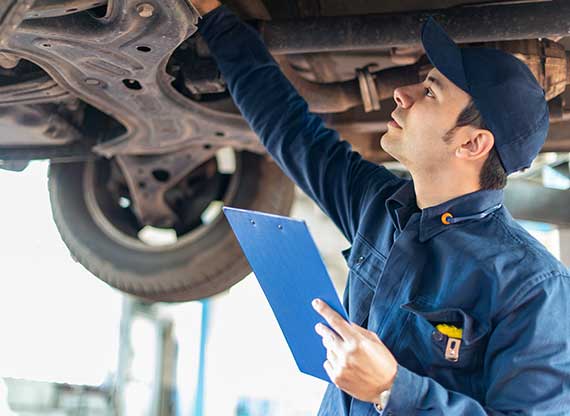 NCC Portrait of a mechanic checking a lifted car to make a quote in his garage