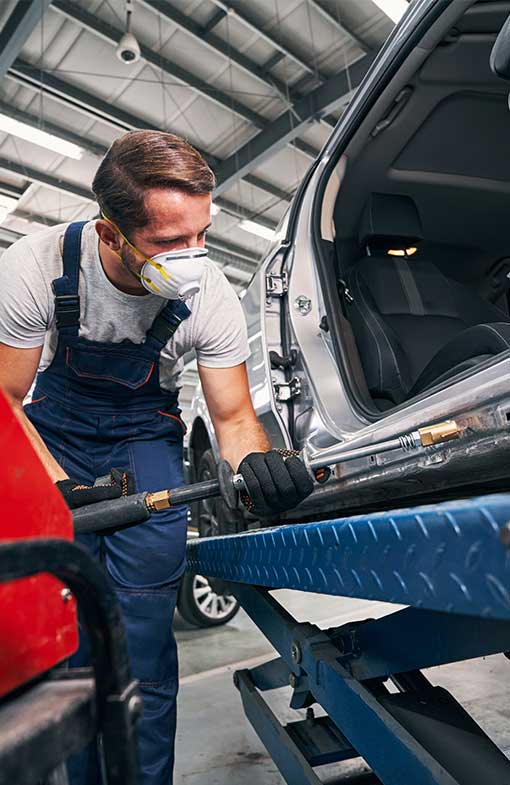 NCC Repairman peening car with tool for removing dents