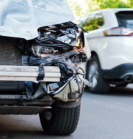 NCC Smashed broken front auto headlight, dented hood no bumper on gray SUV car in car accident.